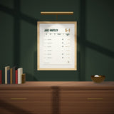 The Record on a dark green wall under a picture light
